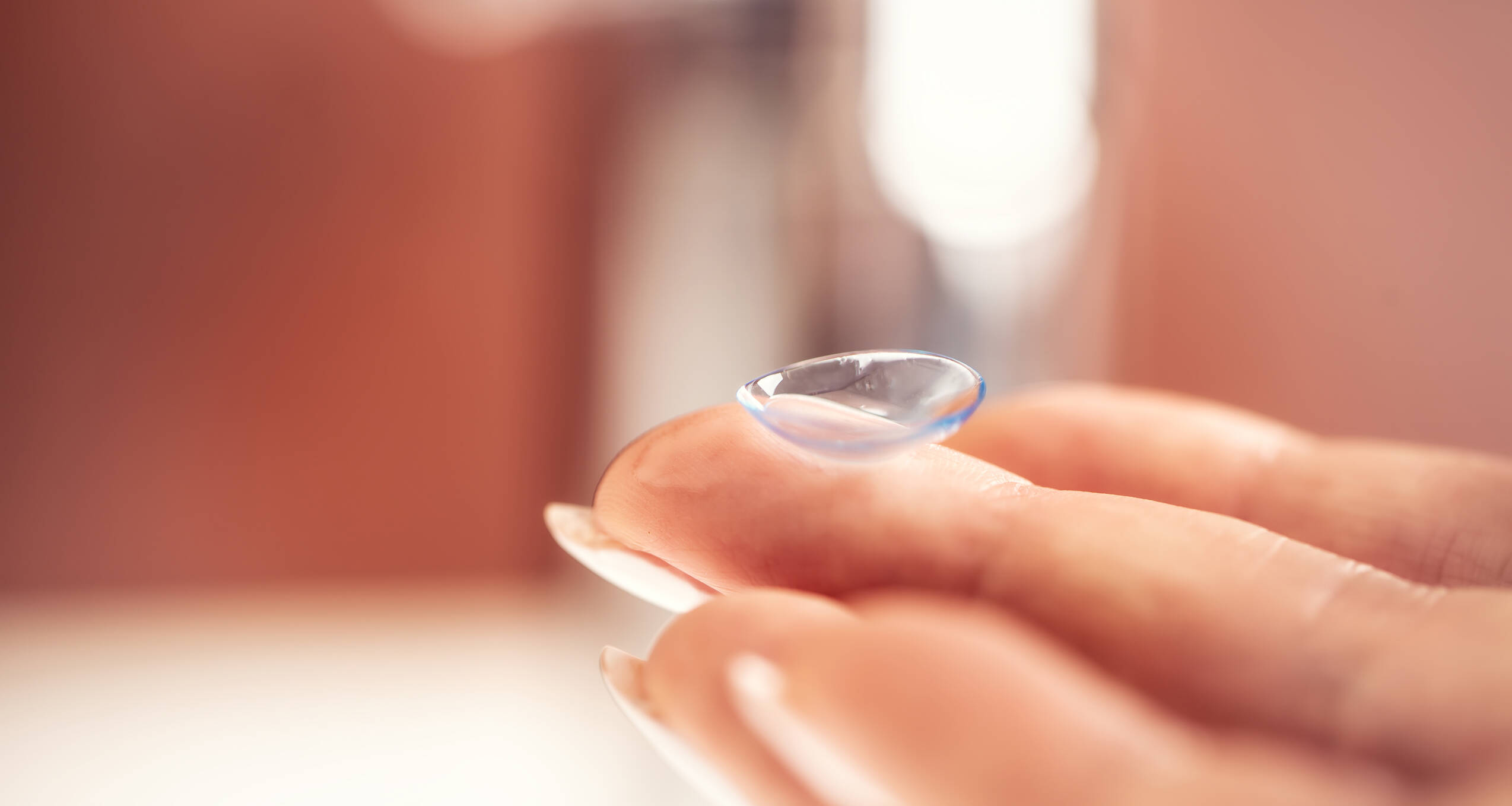 Contact lens fingers young woman before application eye